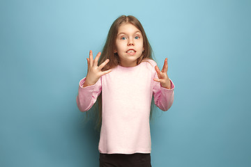 Image showing The surprise, happiness, joy, victory, success and luck. Teen girl on a blue background. Facial expressions and people emotions concept