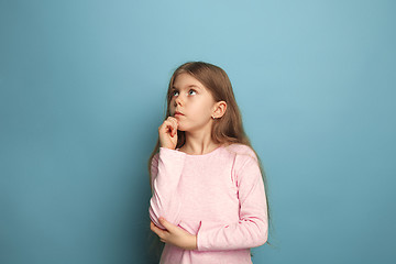 Image showing The thoughtful girl. Teen girl on a blue background. Facial expressions and people emotions concept