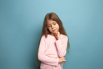 Image showing The thoughtful girl. Teen girl on a blue background. Facial expressions and people emotions concept