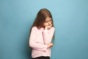 Image showing The thoughtful girl. Teen girl on a blue background. Facial expressions and people emotions concept