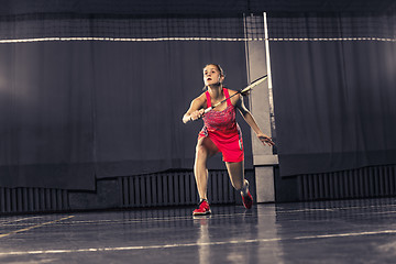 Image showing Young woman playing badminton at gym