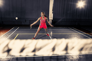 Image showing Young woman playing badminton at gym