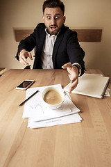 Image showing Coffee in white cup spilling on the table in the morning working day at office table