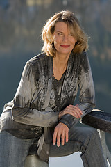 Image showing elderly lady in fashionable blouse enjoys the sunshine in your face