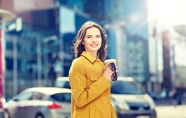 Image showing happy young woman drinking coffee on city street