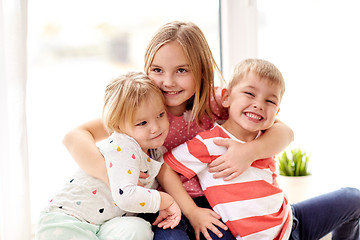 Image showing happy little kids hugging at window