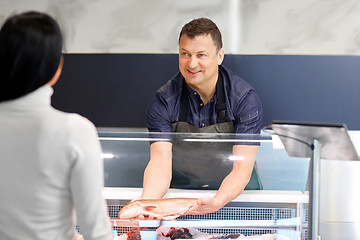 Image showing seller showing seafood to customer at fish shop