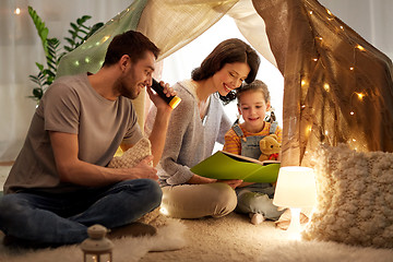 Image showing happy family reading book in kids tent at home