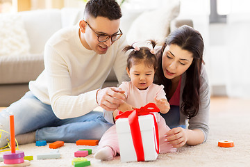 Image showing baby girl with birthday gift and parents at home 