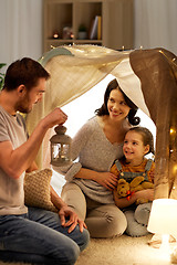 Image showing happy family playing in kids tent at night at home