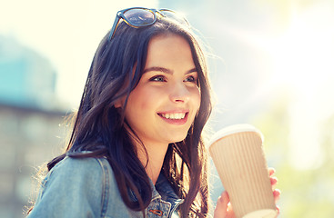 Image showing happy young woman drinking coffee on city street