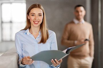 Image showing smiling female office worker with folder