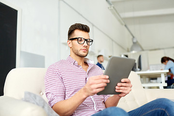 Image showing man in glasses with tablet pc working at office