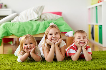 Image showing happy little kids lying on floor or carpet