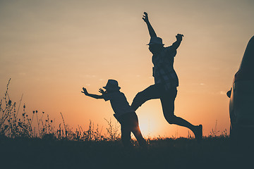 Image showing Father and son playing in the park at the sunset time.