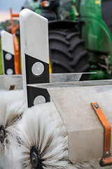 Image showing Tractor cleaning reflector posts