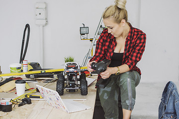 Image showing Female checking functions of radio-controlled car