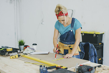 Image showing Woman drawing line on plywood in workshop 