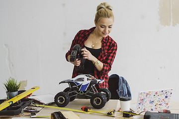 Image showing Woman playing with radio-controlled car in workshop
