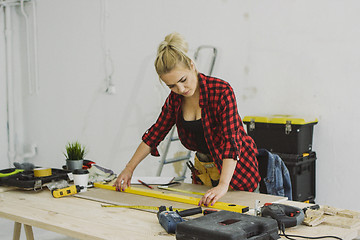 Image showing Woman using spirit level on workshop desk 