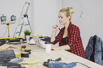 Image showing Sitting at workbench female using laptop 