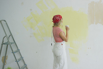 Image showing Female painter with drink looking at wall