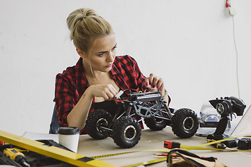 Image showing Female repairing radio-controlled car 