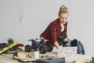 Image showing Female with radio-controlled car using laptop