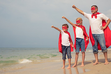 Image showing Father and children playing superhero on the beach at the day ti