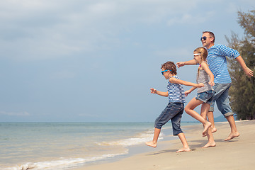 Image showing Father and children  playing on the beach at the day time.