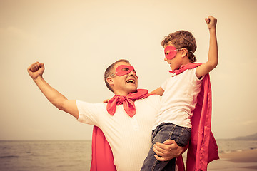 Image showing Father and son playing superhero on the beach at the day time.