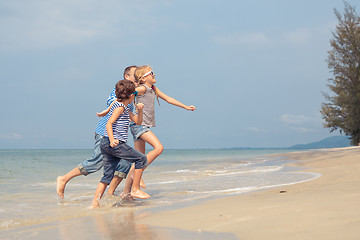 Image showing Father and children  playing on the beach at the day time.