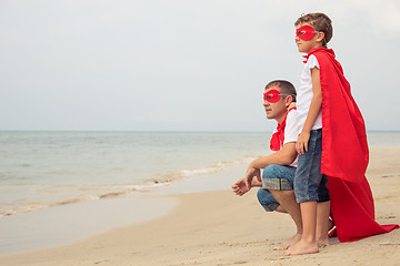 Image showing Father and son playing superhero on the beach at the day time.