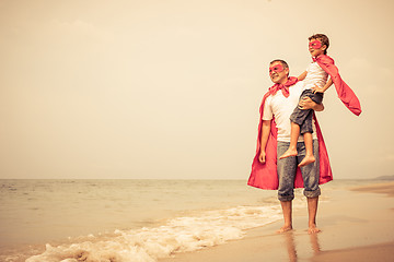 Image showing Father and son playing superhero on the beach at the day time.