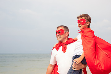 Image showing Father and son playing superhero on the beach at the day time.