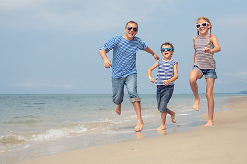 Image showing Father and children  playing on the beach at the day time.