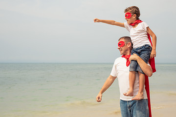 Image showing Father and son playing superhero on the beach at the day time.