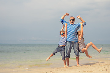 Image showing Father and children  playing on the beach at the day time.