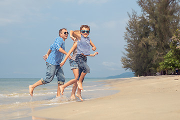 Image showing Father and children  playing on the beach at the day time.