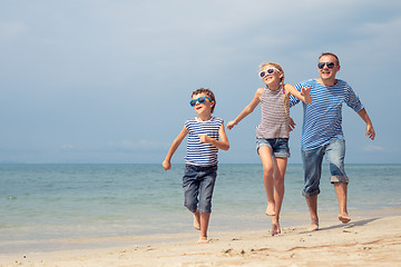 Image showing Father and children  playing on the beach at the day time.