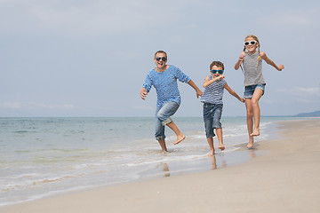 Image showing Father and children  playing on the beach at the day time.