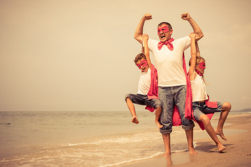 Image showing Father and children playing superhero on the beach at the day ti