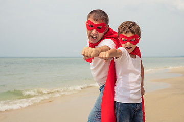 Image showing Father and son playing superhero on the beach at the day time.