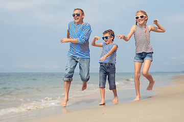 Image showing Father and children  playing on the beach at the day time.