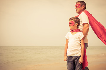 Image showing Father and son playing superhero on the beach at the day time.