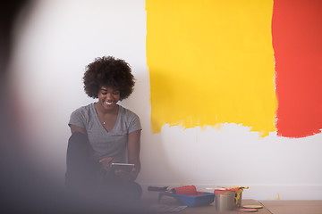 Image showing back female painter sitting on floor