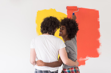 Image showing multiethnic couple painting interior wall