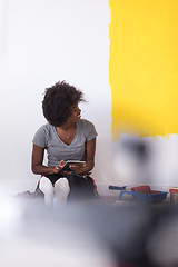 Image showing back female painter sitting on floor