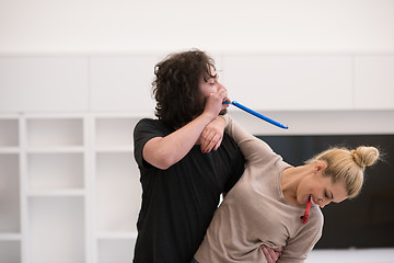 Image showing couple in party hats blowing in whistle