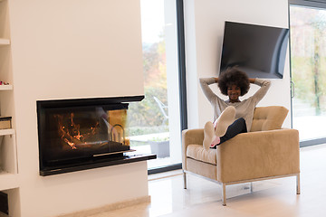 Image showing black woman in front of fireplace